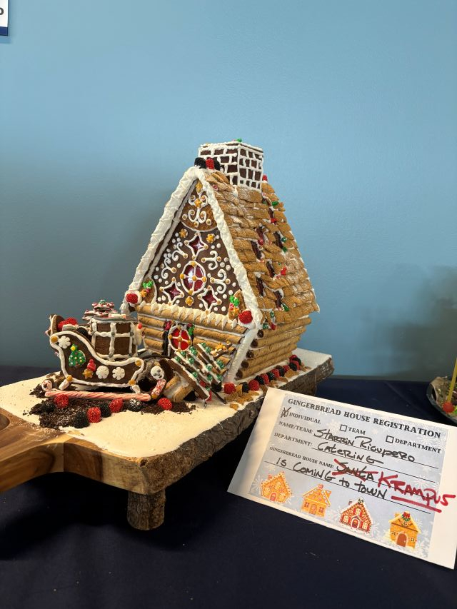 log cabin gingerbread house with frosting and candy
