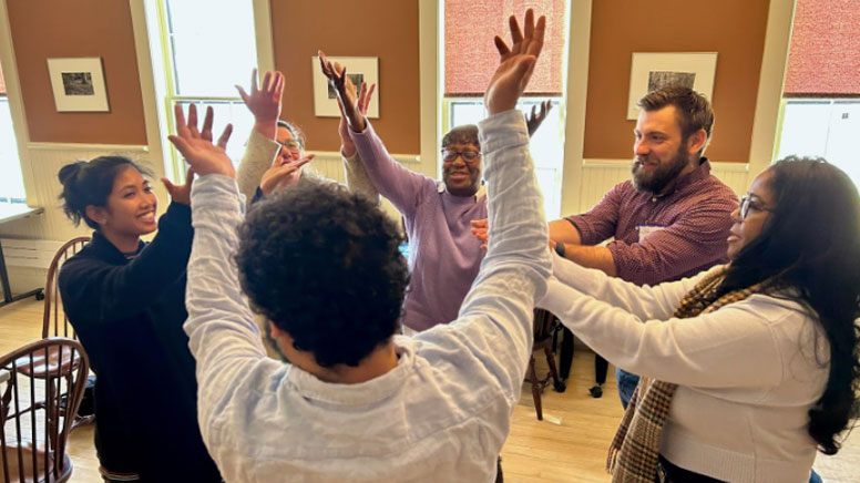 Students in a circle with raised hands