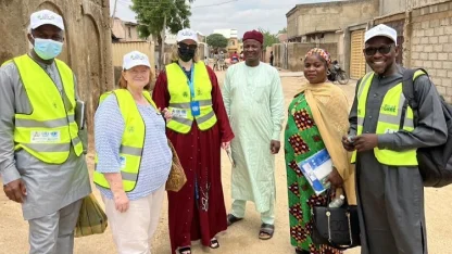 Student, Elena Klein '23 stands amongst voluteers and locals on a street in Nigeria.