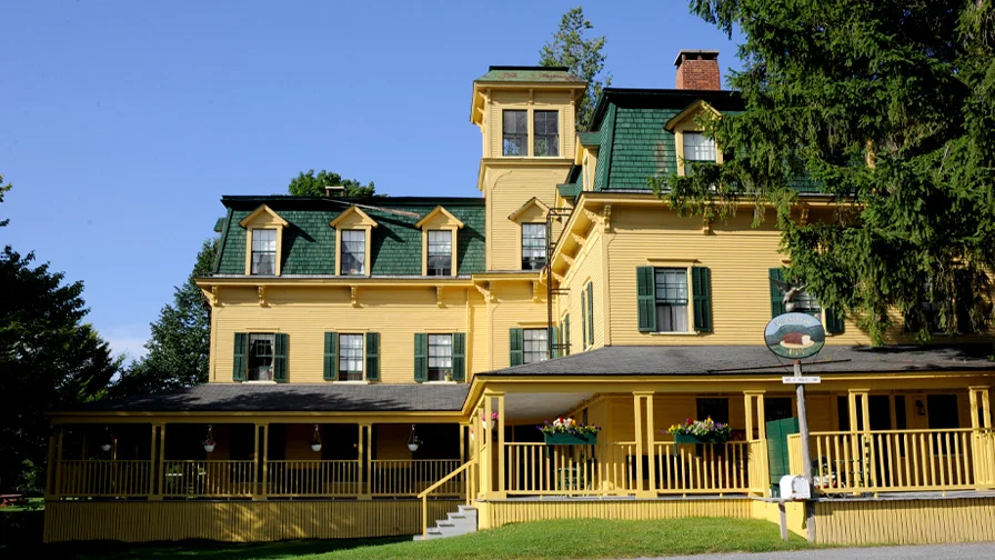 Students gather and observe the side of a building with elaborate carvings and paintings in another country.