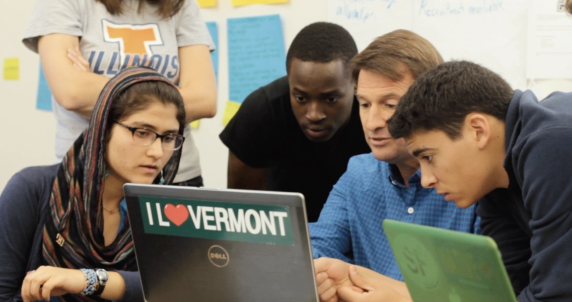 MiddCORE students gathered around computer with mentor