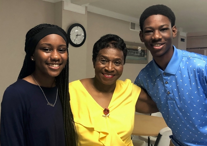 Two women and one man pose and smile at the camera.