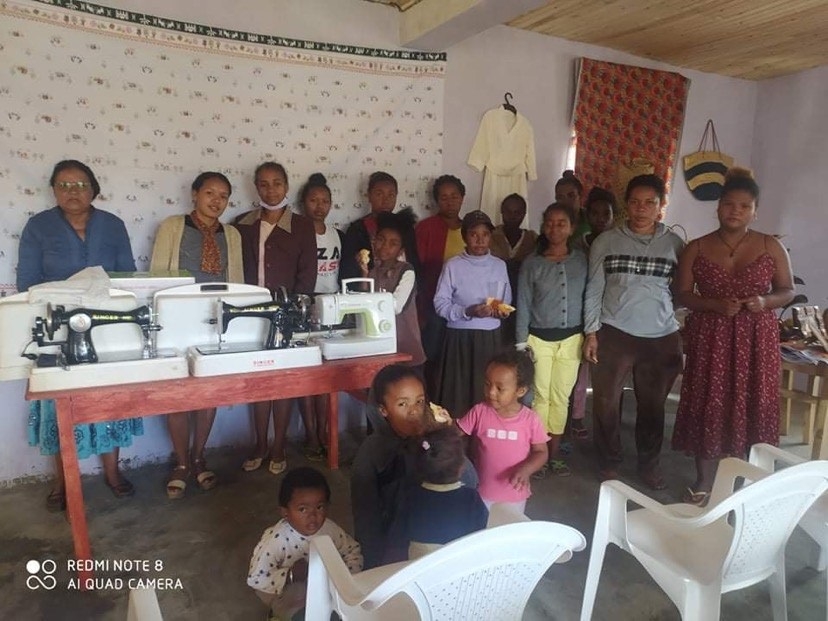 Women stand by sewing machines in the Handicraft Training Center developed by Kimberly Arevalo