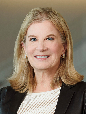 headshot of Sally Thurston, wearing a black blazer over a white patterned shirt