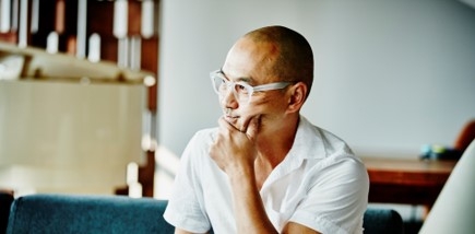 A man with his hand on his chin, appearing to be thinking.