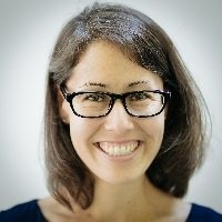 headshot of Huang smiling with glasses