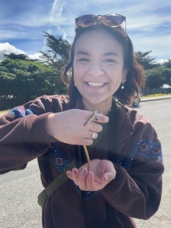 Student smiling and holding a small snake