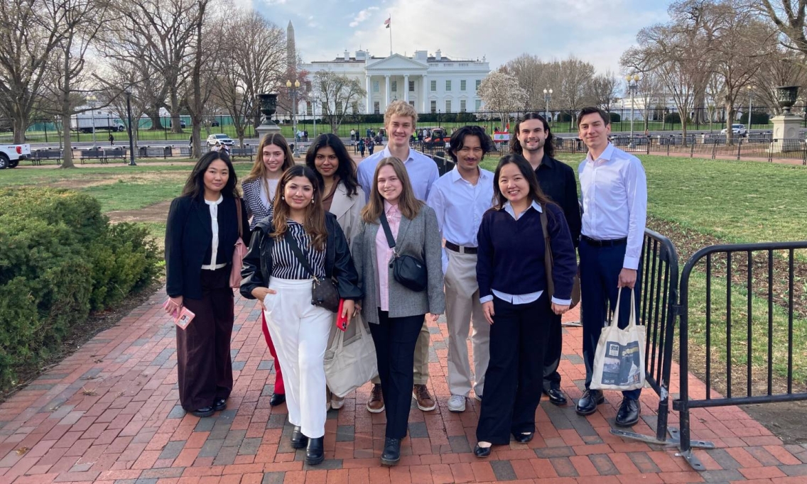 A group of Middlebury students pose standing in front of the White House in Washington, DC.