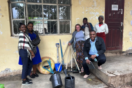 Stankewich (c) with, from l-r: Glady, program manager at WEHAF; Theresia Mollel, director and co-founder of WEHAF; Michael, garden supervisor at Felix Secondary School in Arusha; Happy and Rehema, two women who have been supported by WEHAF and who provided integral farming help to prepare and cultivate the land for the gardens.