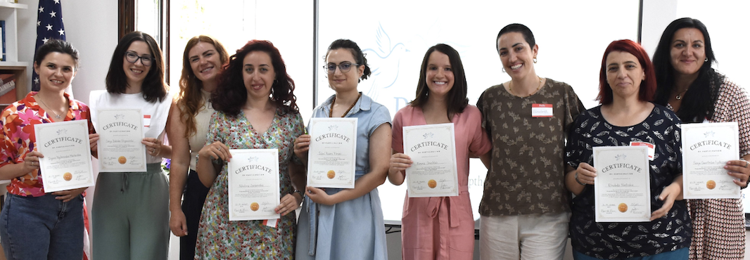 The recent Institute graduates with educators who completed their workshop on peacebuilding through language education pose with certificates.