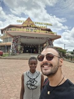 Two people smiling in front of a building