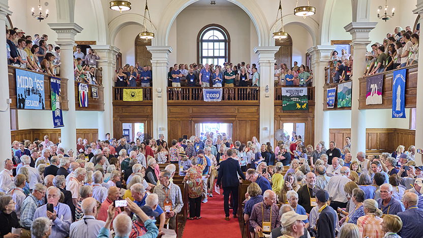 Classes and their banners between 2020 and 1950 pack the Middlebury Chapel during Reunion 2025