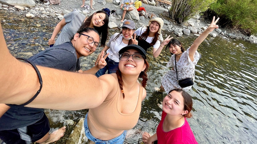 Students working abroad to clean up a waterway.