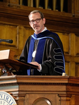Ian Baucom at a podium in his Middlebury regalia.