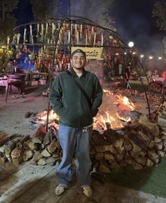 Student posing in front of a fire