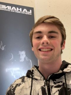 Student smiling in front of a poster