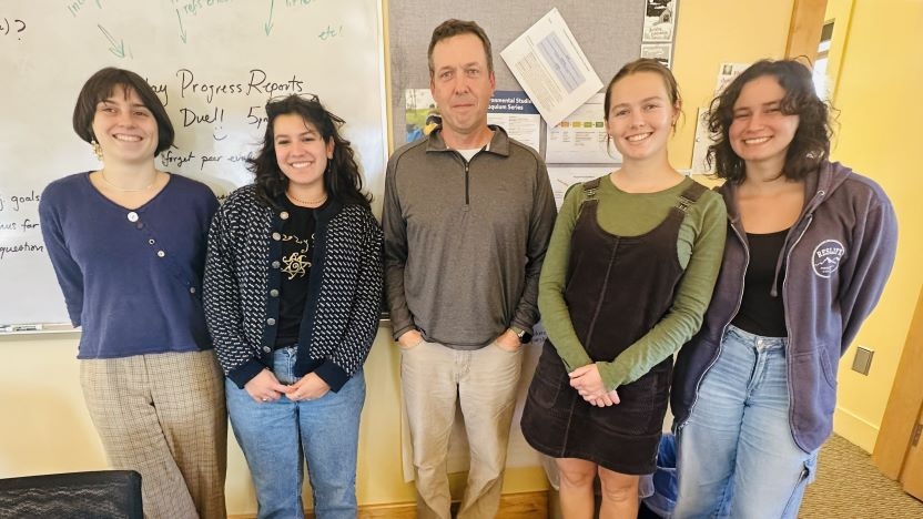 Four students and one community partner pose for photo