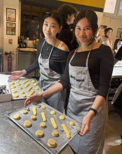 Two students posing with trays of baked goods