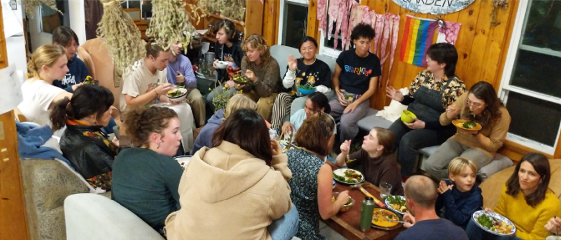 Group gathered for dinner in a circle at Weybridge House