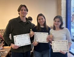 Three friends smiling holding certificates 