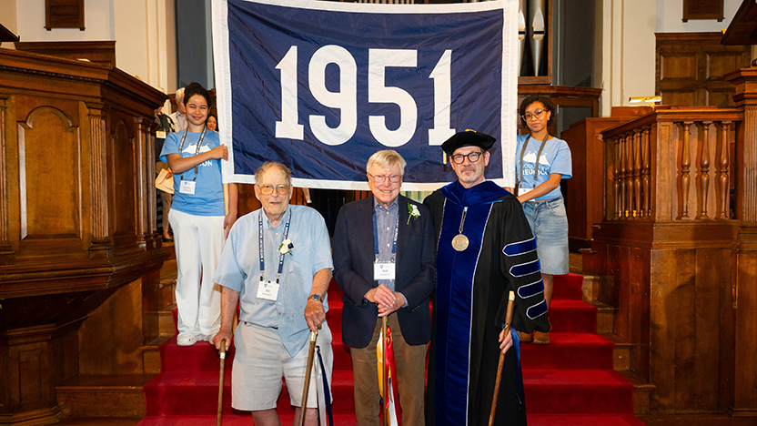 Two members of the class of 1951 at Reunion Convocation with President Ian Baucom and bearers of their class banner. 