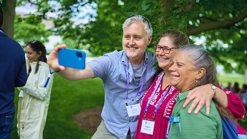 Three friends from the class of 1991 take a selfie, arm-in-arm