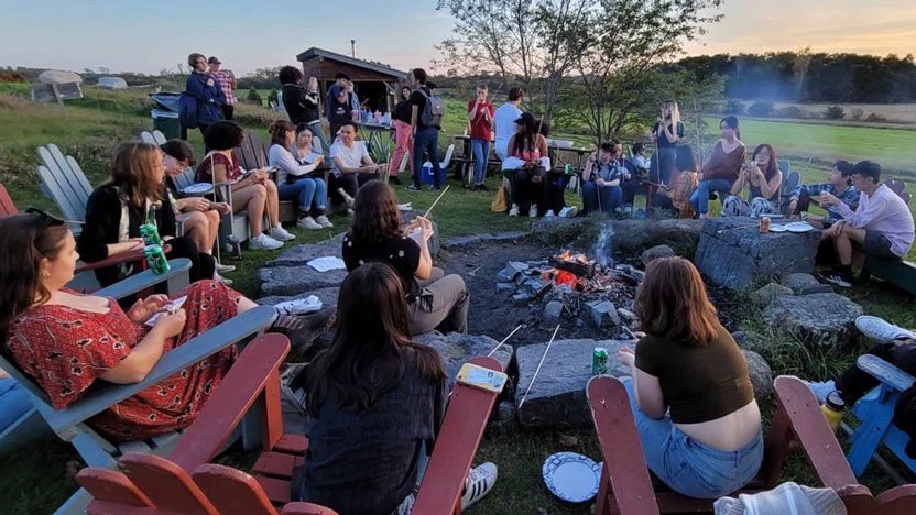 Students enjoying a bonfire at the Knoll, Middlebury's community garden.