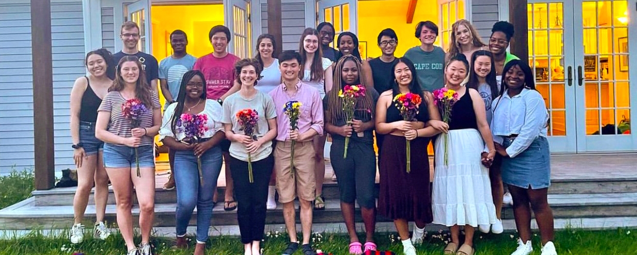 Scott Center students in front of building holding flowers.