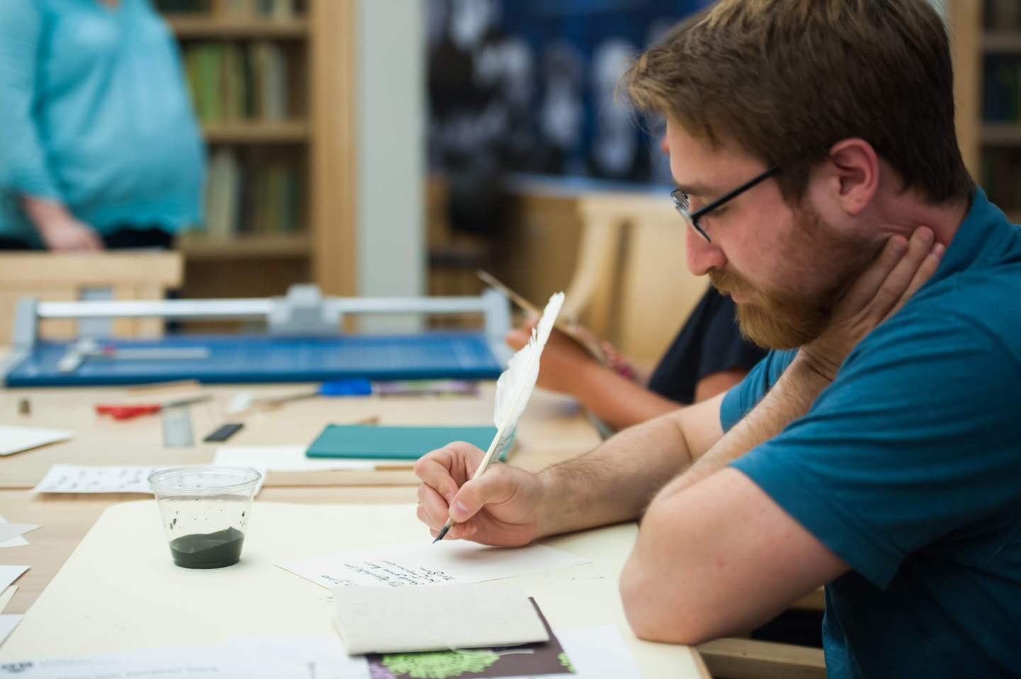 Man writes with feather quill. 