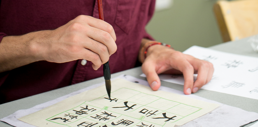 Close up of hands painting Chinese characters 