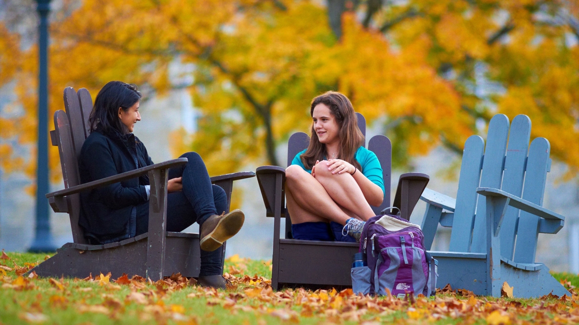 Alum and Student sit in Adirondack Chairs and Chat