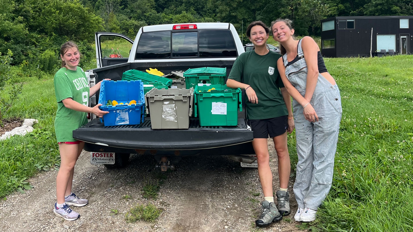 Students standing behind a pickup truck filled with local produce.