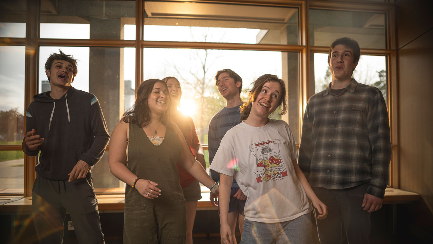An a capella group of young men and women perform in the dining hall.