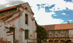 the rust-red roofs of an Ecuadorian factory backed by a brilliant blue sky