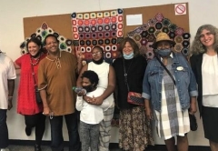 Group photo of six adults and one child looking into the camera