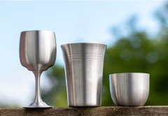 Pewter Cups resting on a wooden table outside