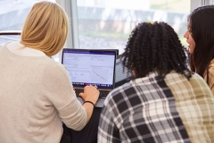 three students looking at a computer