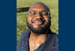 Photo of Kahari Blue looking outside looking up into the camera with a green grass background