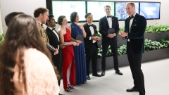 Prince William laughing with a crowd at party.