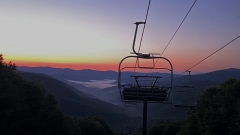 Chair lift looking over mountains at sunset