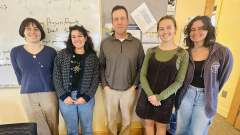 Five people stand for a photo. Geoff Wilcox (center) 