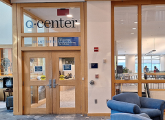 Wood and glass door entrance with Q-Center lettering above