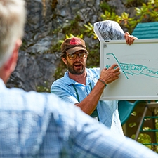 Two people participate in the Alumni College class, outdoors.