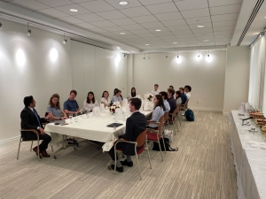 Conflict Transformation Trek crew sitting in  a large, white conference room