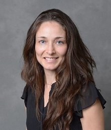 white woman with long dark hair and black short-sleeved shirt