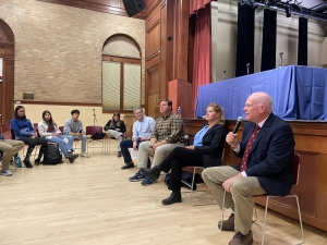 Four local Vermont representatives sit in a circle speaking with Middlebury students.