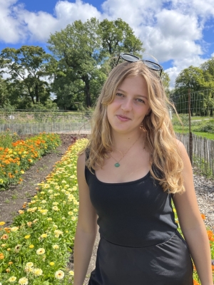 A student wearing a black dress in a flower garden