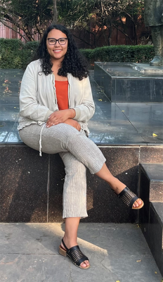 Black sitting with legs crossed on stone stairs
