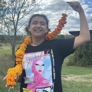 person smiling holding marigold string