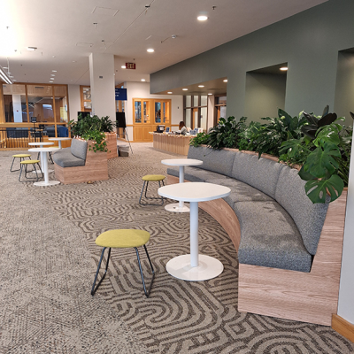 bench of seats with small round tables and plants